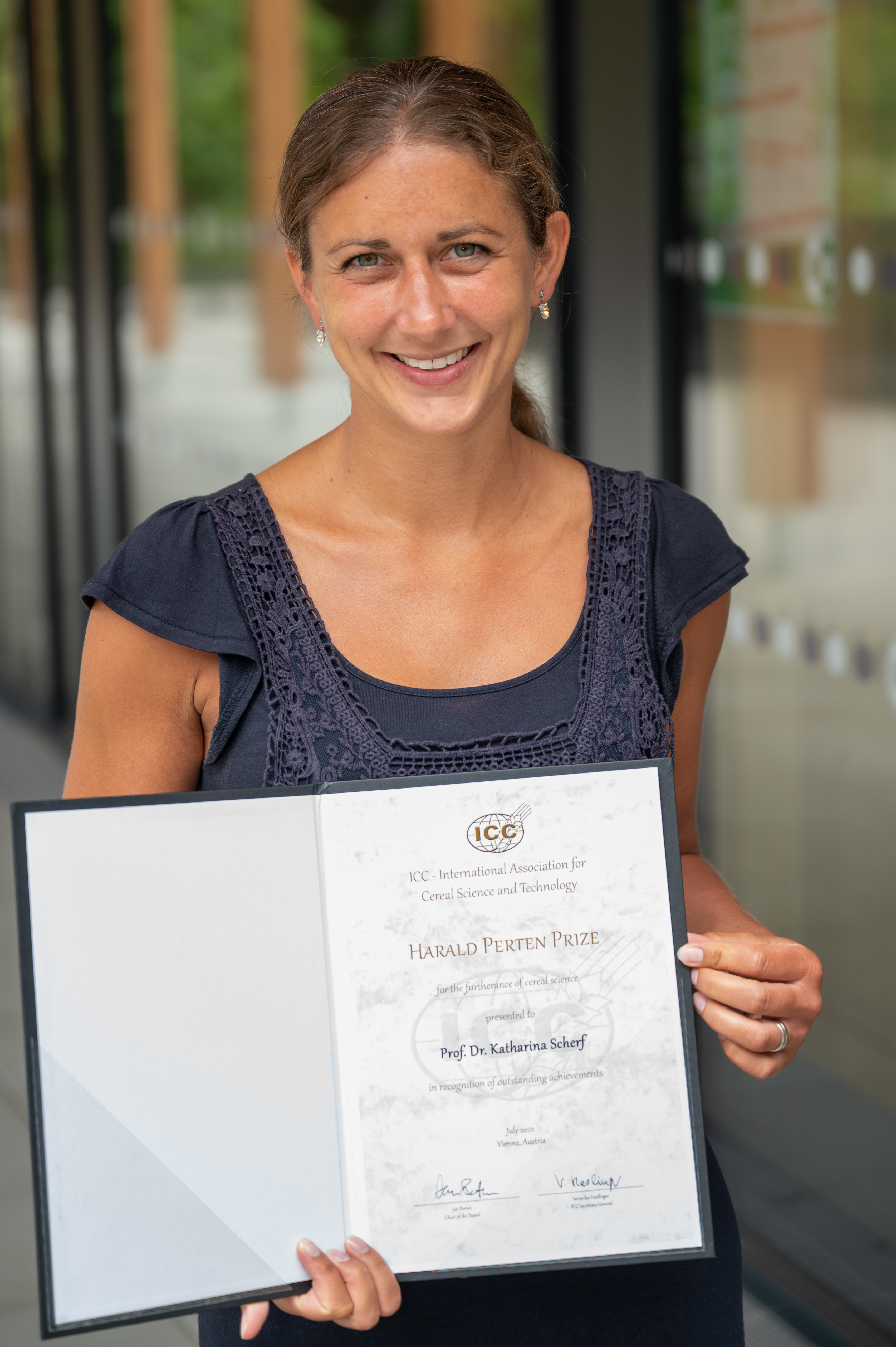 Katharina Scherf holding the certificate of the Harald Perten Prize awarded by the International Association for Cereal Science and Technology (ICC)